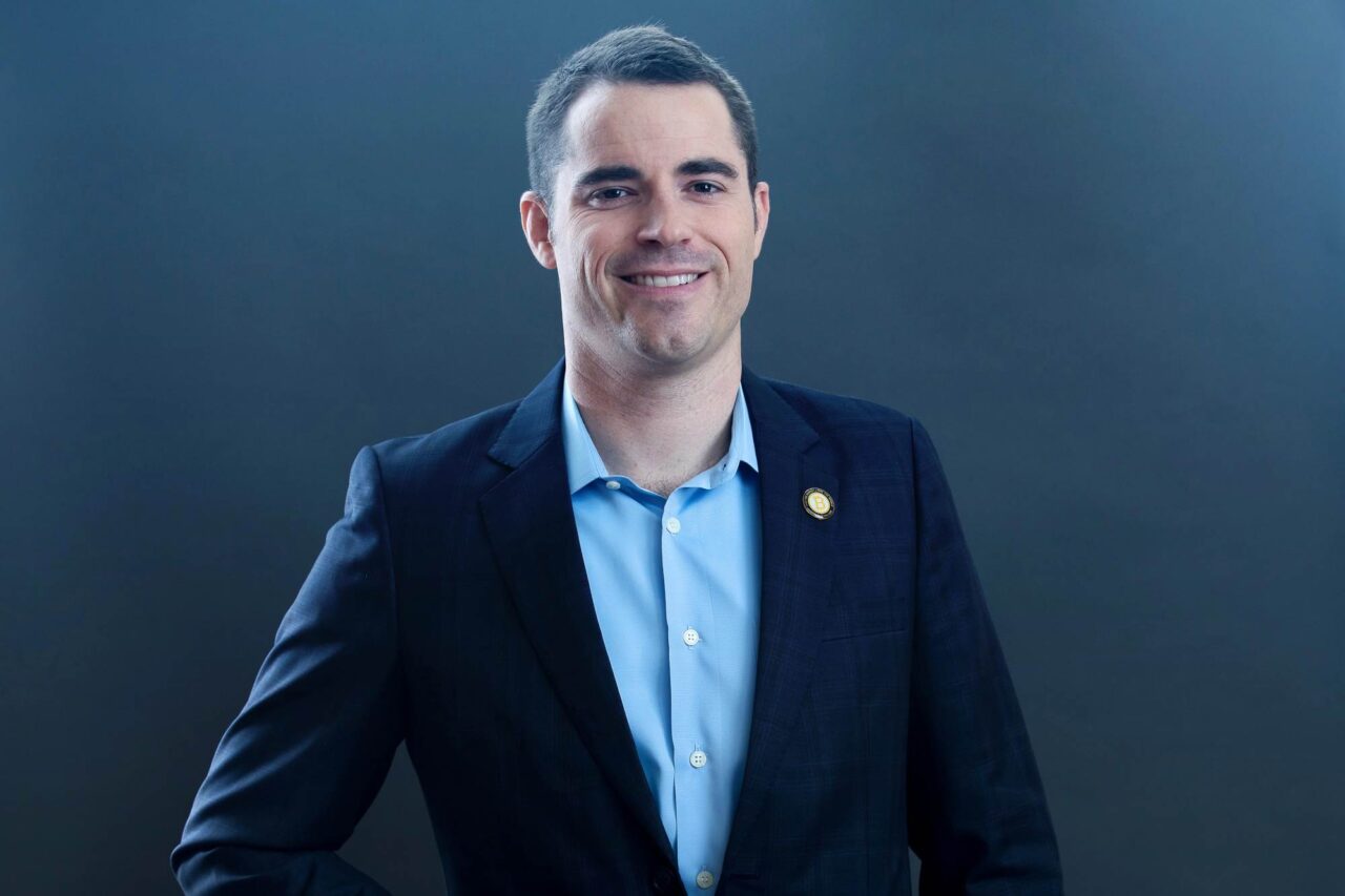 Roger Ver poses in a suit following his $48 million DOJ tax fraud settlement.