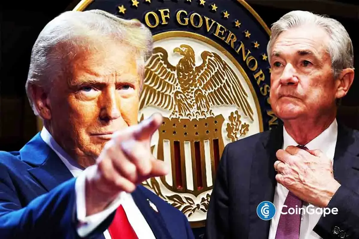 Trump points forward as Jerome Powell adjusts his tie, highlighting tension over upcoming Fed Reserve chair change.